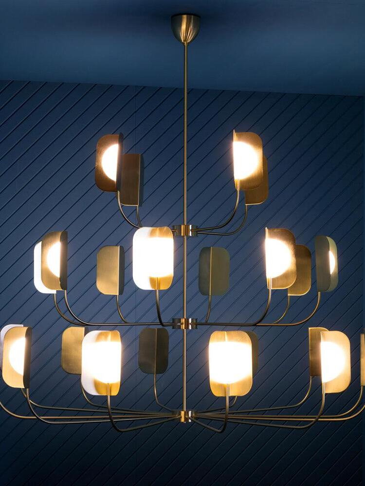 Large tiered LEAF chandelier against a dark blue wall