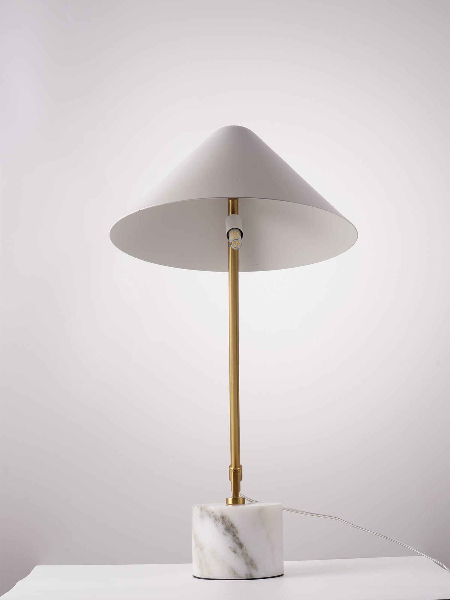 Front underside view of white shade, exposed small bulb and upright gold-tone arm