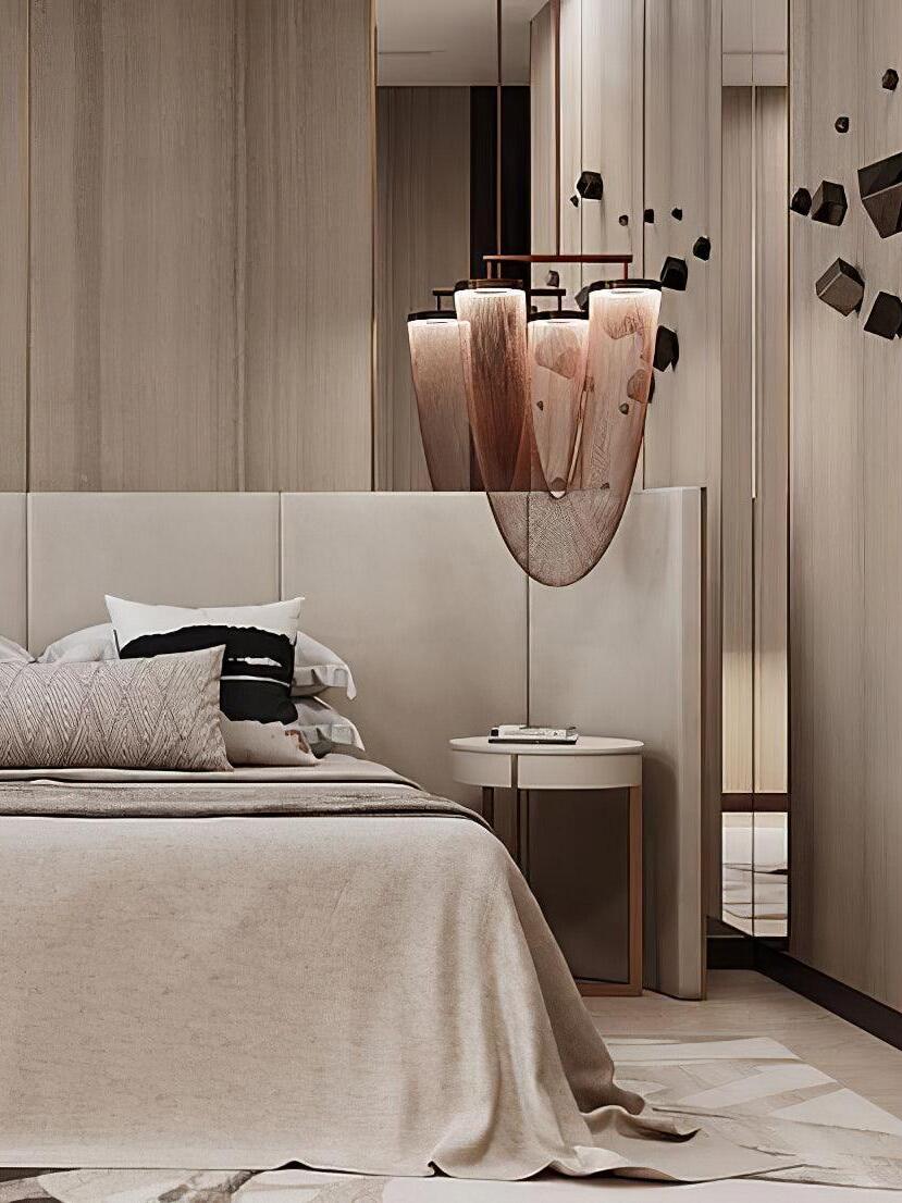 Rose-gold chain chandelier beside a bed