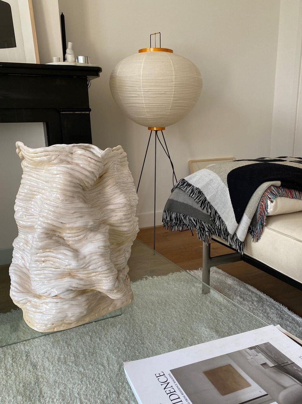 Round paper lamp beside sofa