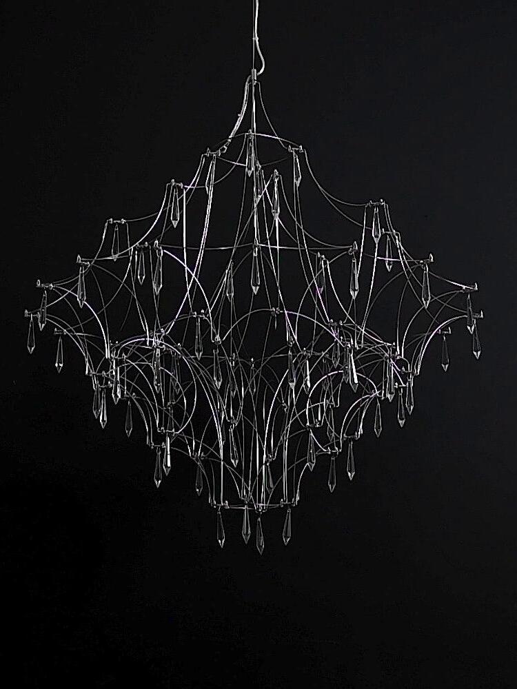 Unlit Silver lattice chandelier against a dark background