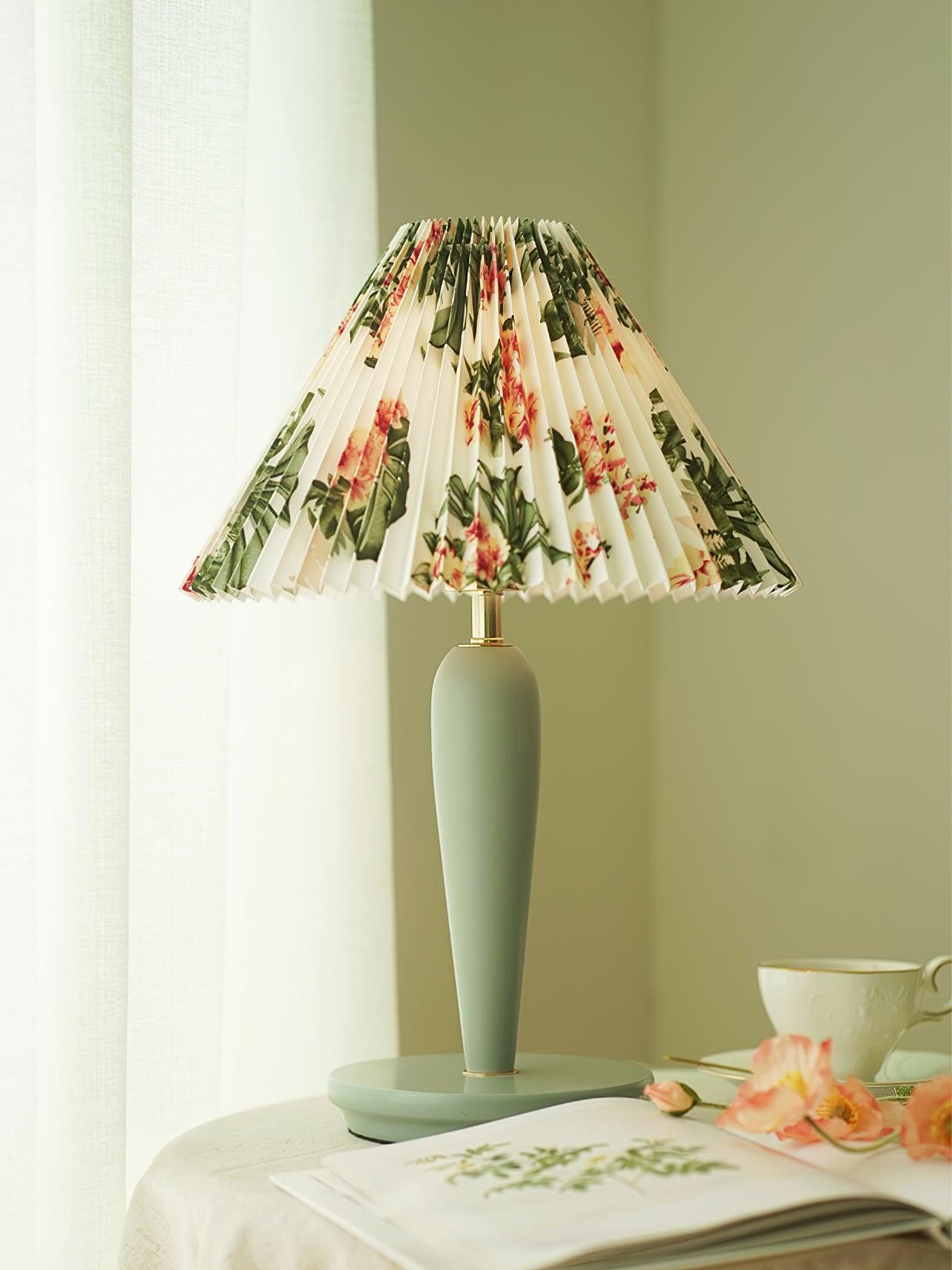 Light-blue lamp with floral shade on covered side table