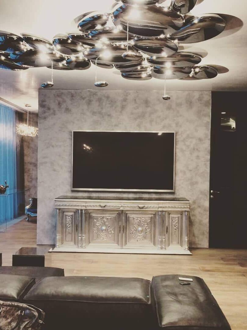 Large reflective ceiling grouping above fireplace and dark seating