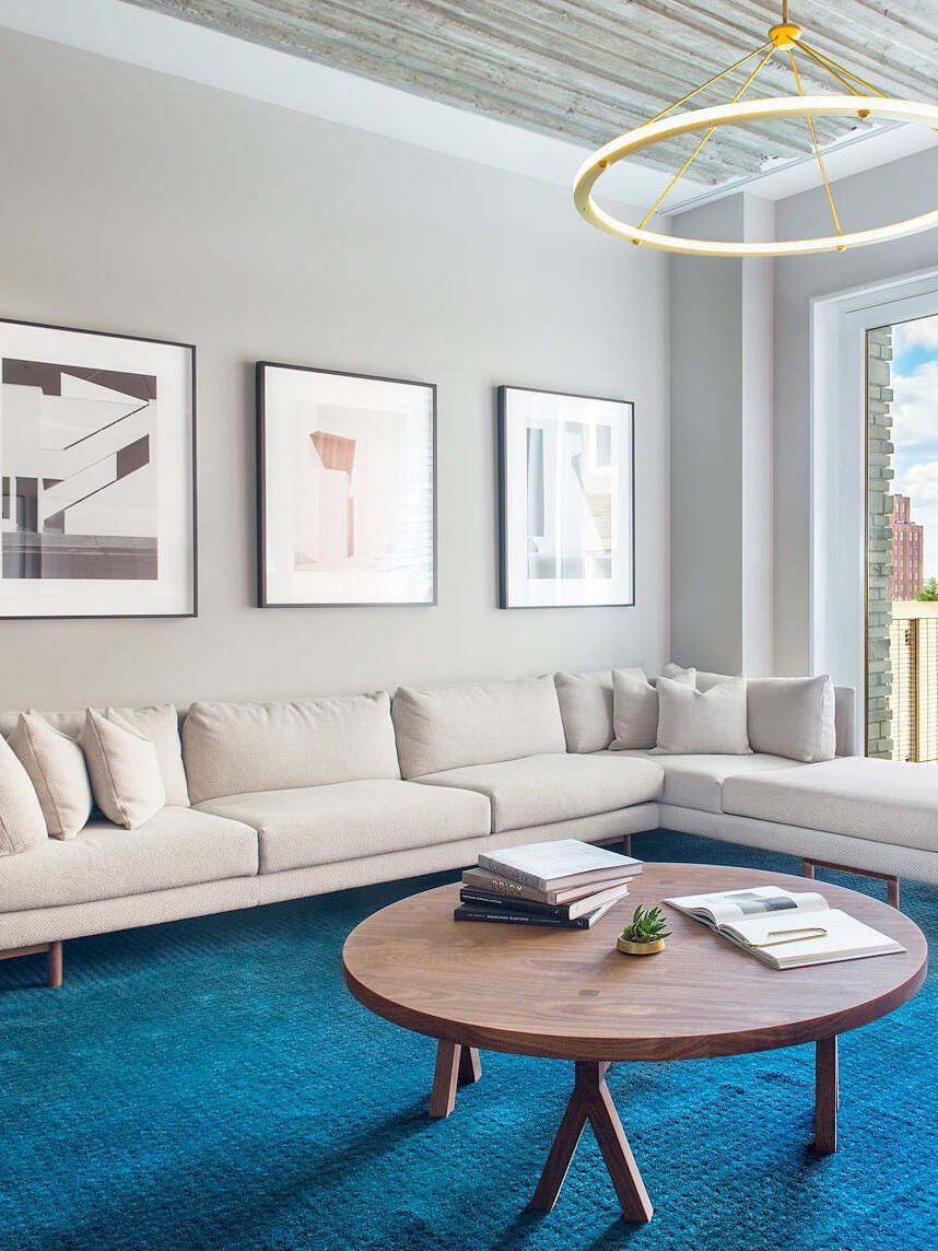 Gold ring pendant above sofa and round coffee table