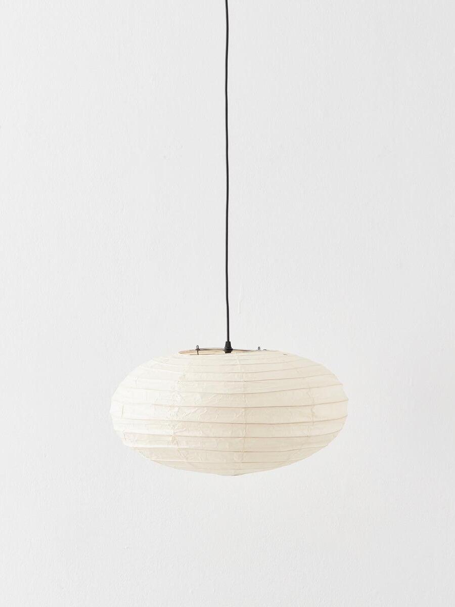 Flattened pale paper lantern with widely spaced ribs on a black suspension cord against a white wall