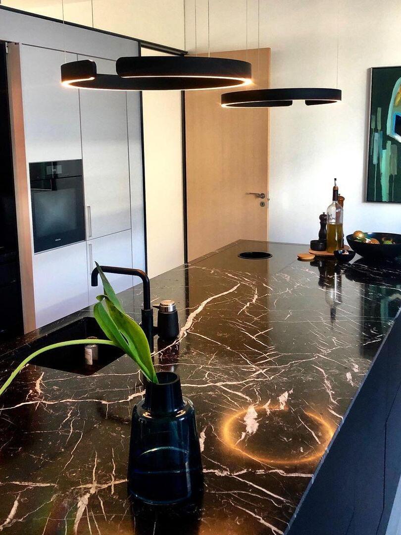 Black ring pendants above a dark stone counter