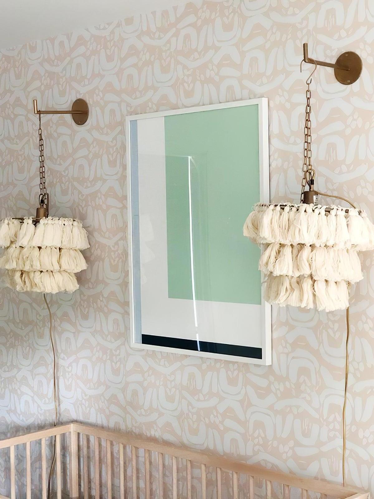 White tassel lights beside framed wall art
