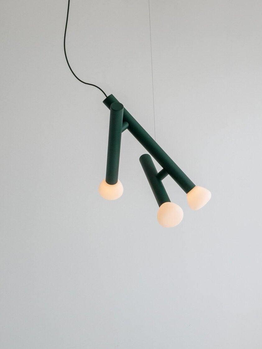 Green angular three-head pendant against a pale wall