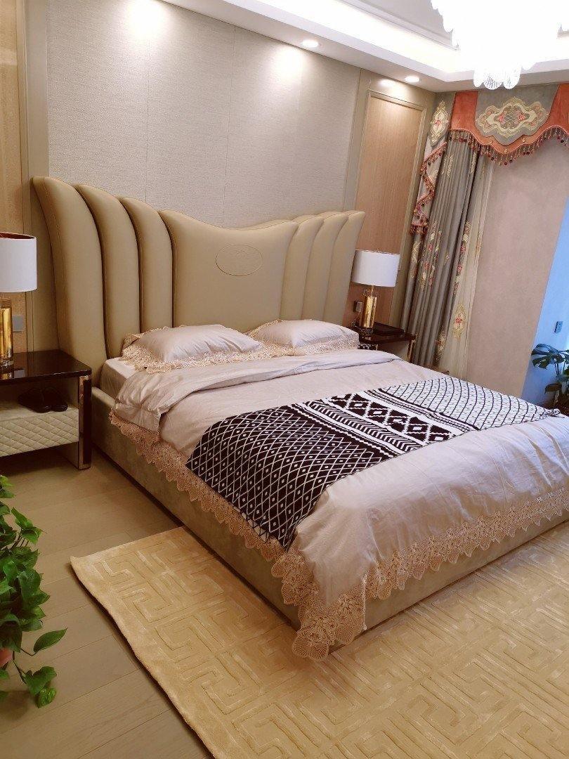 Bedroom with padded headboard and white-shade lamps on bedside tables