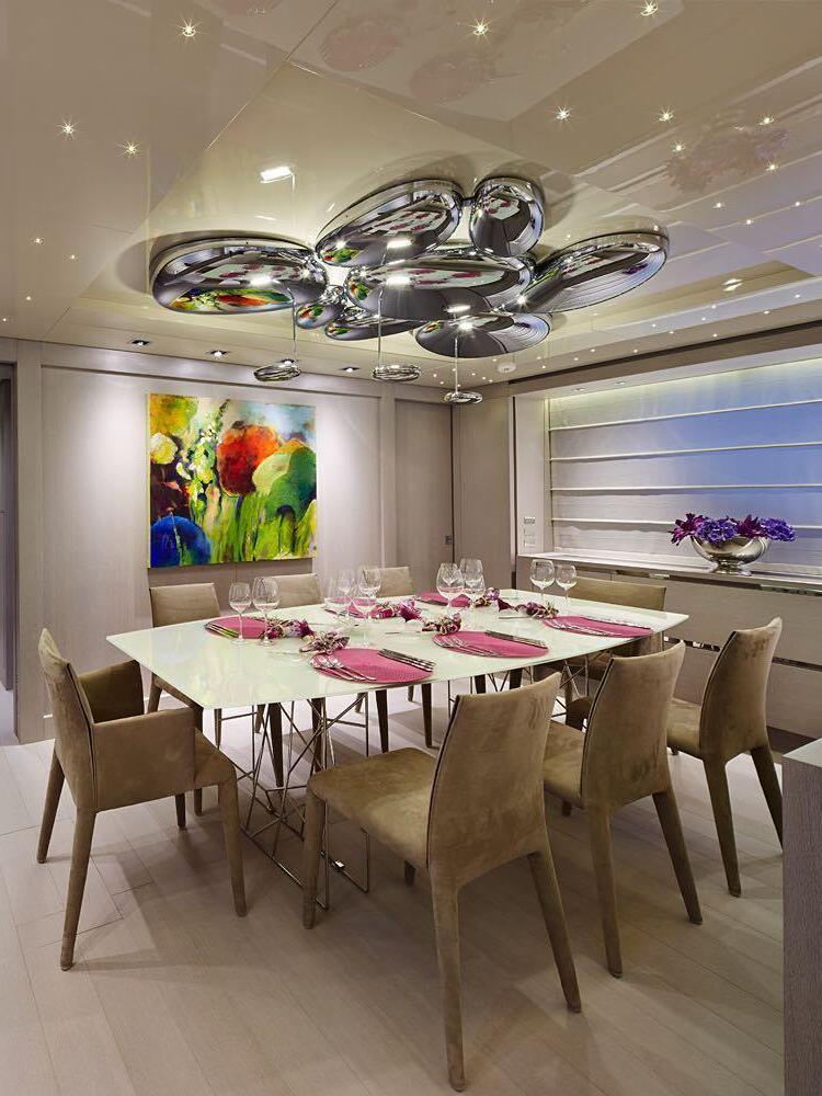 Chrome pebble ceiling cluster above oval dining table and upholstered chairs