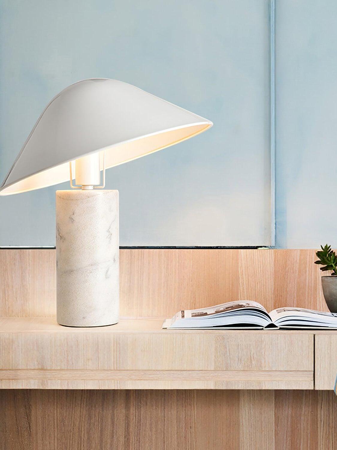 White marble table lamp beside open book