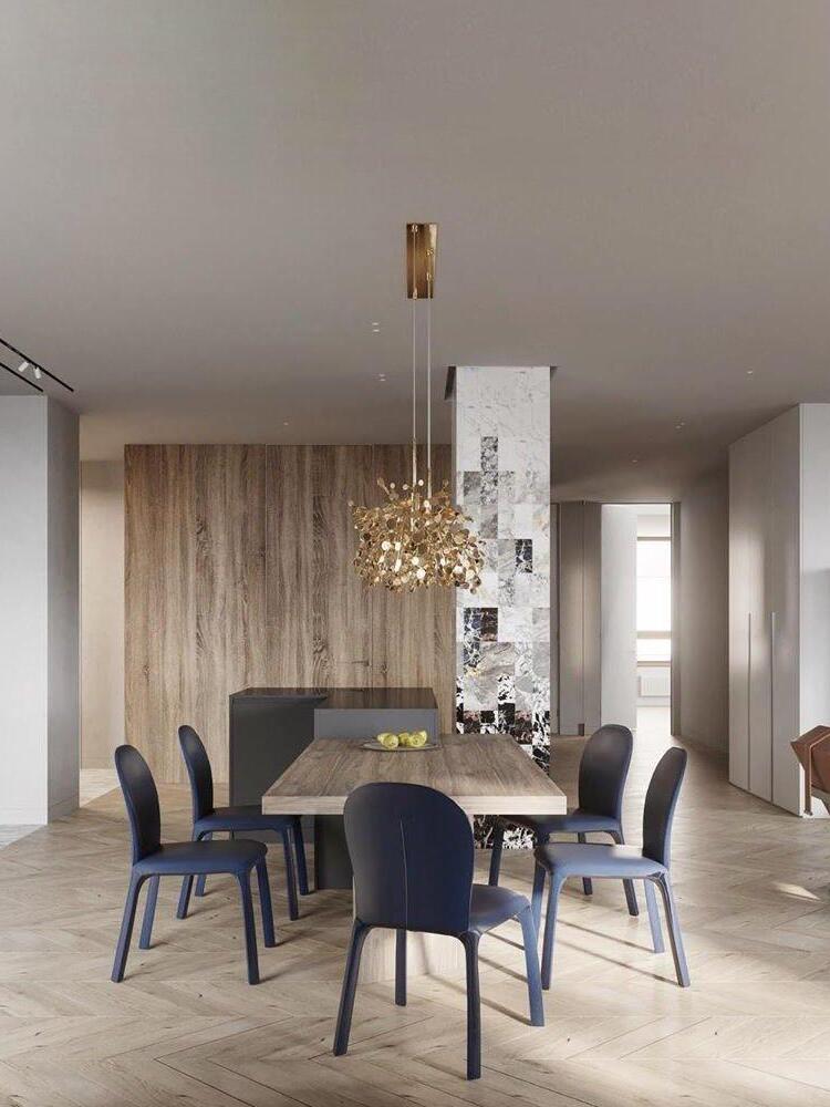 Gold-toned disc chandelier above a dark dining table
