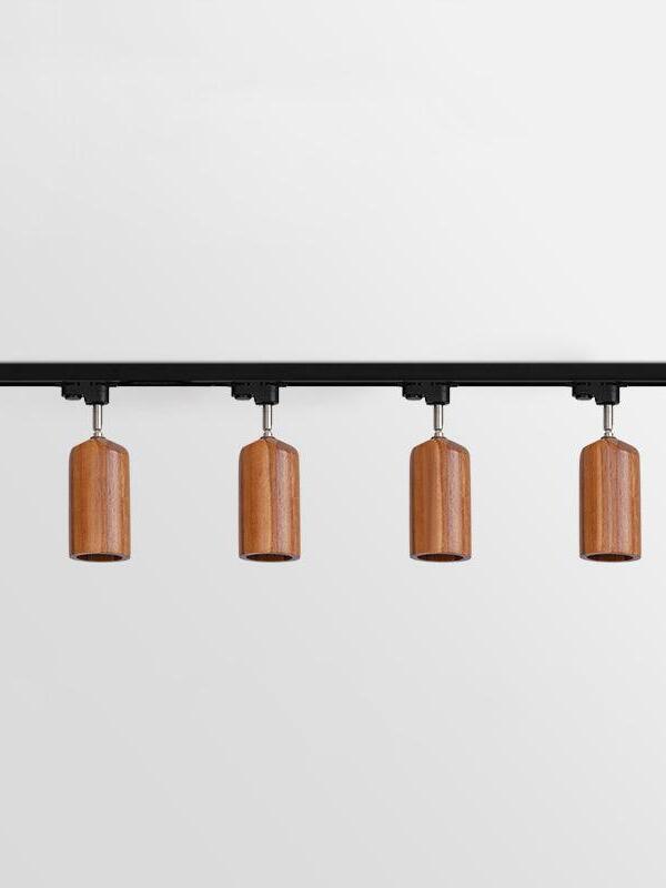 Four dark cylindrical wooden spots on black bar