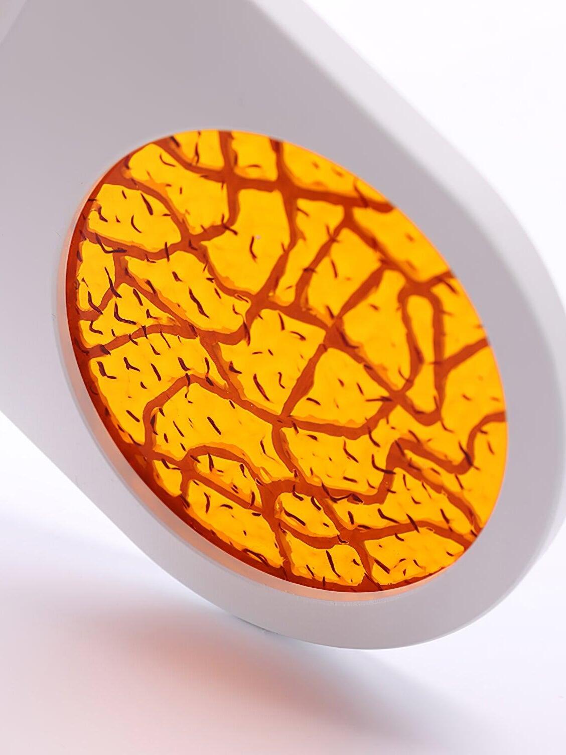 Angled close-up of the white Nights upper light with branching patterns across an orange glow