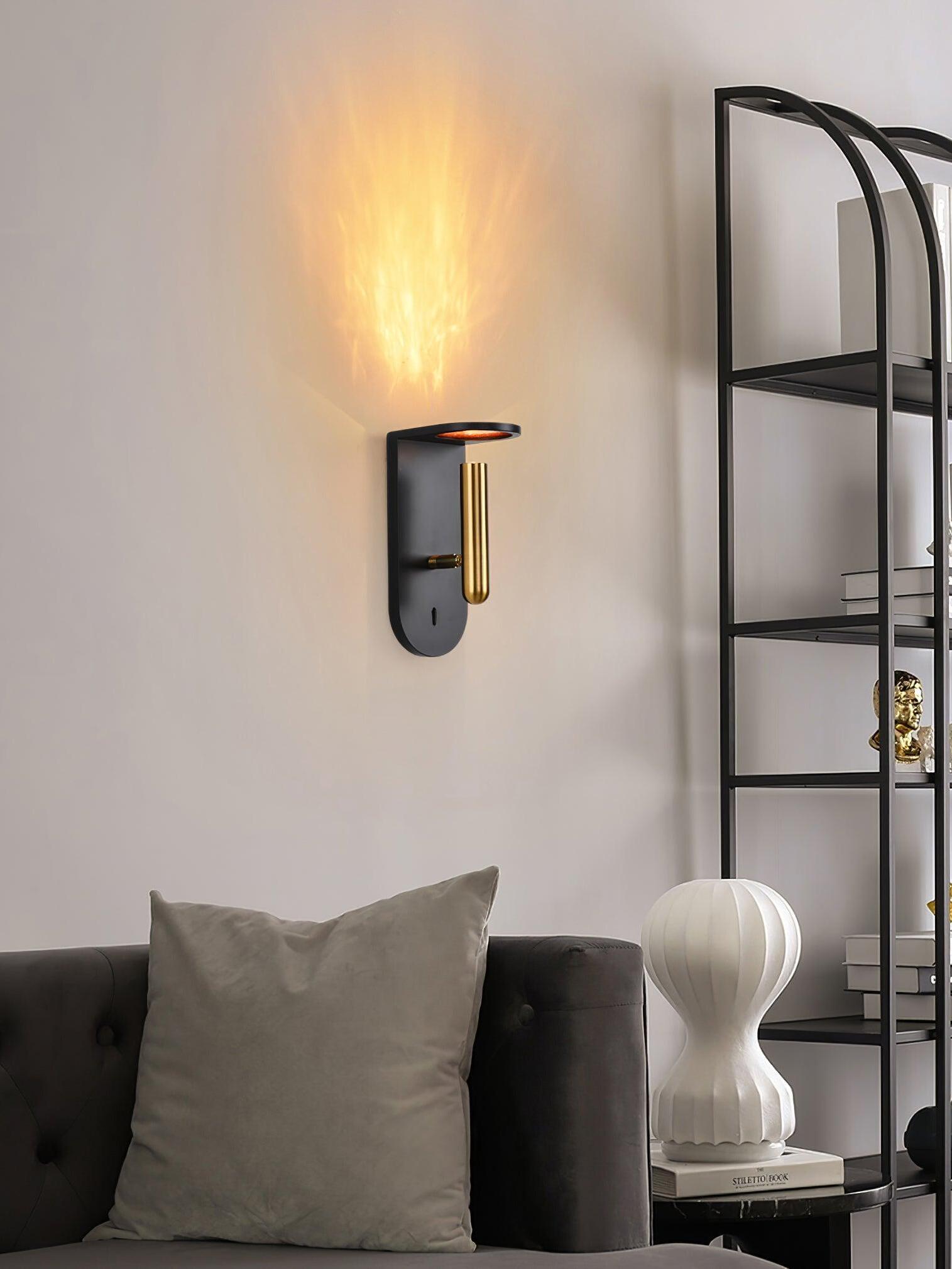 Black Nights wall light above a grey sofa beside framed artwork, a vase and shelving