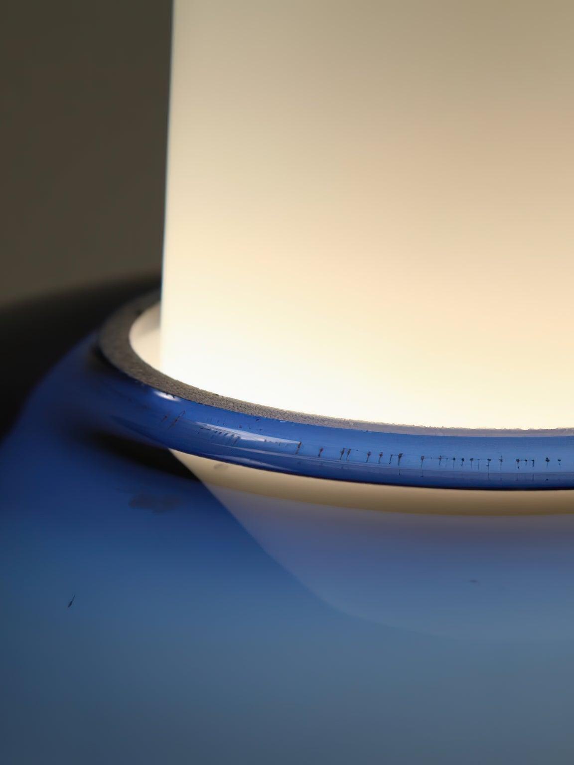 Detail of the glossy blue band surrounding the illuminated white neck of the Trendy pendant.