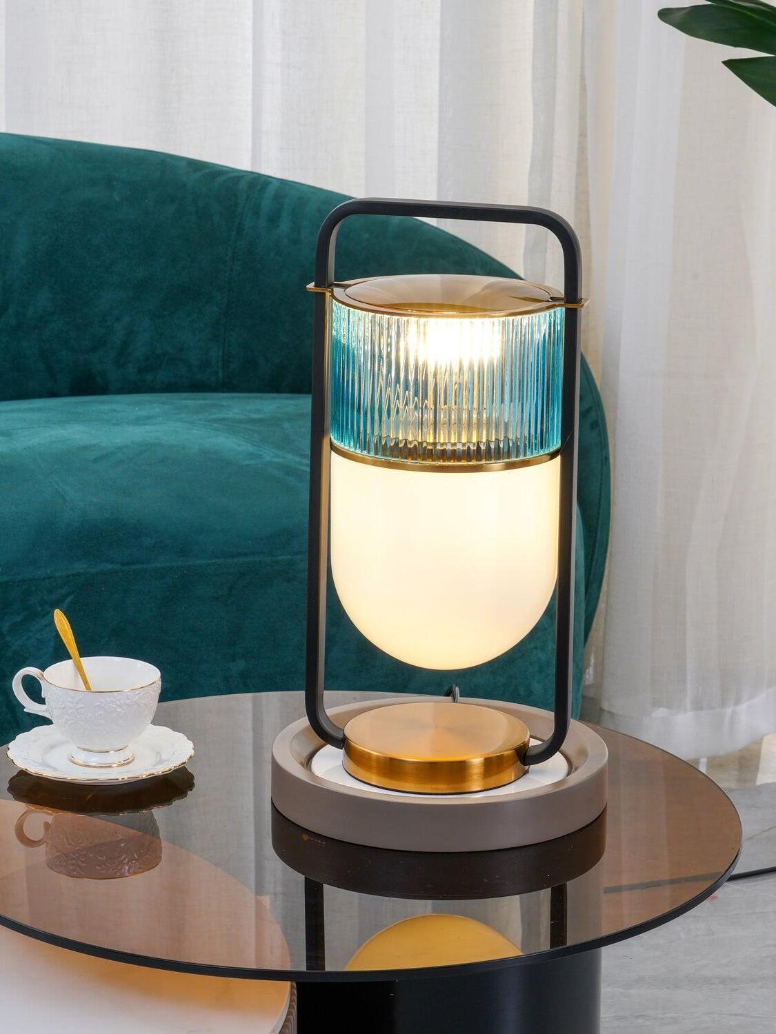 Close view of illuminated blue-green ribbed glass and rounded lower shade beside a cup on a glass table
