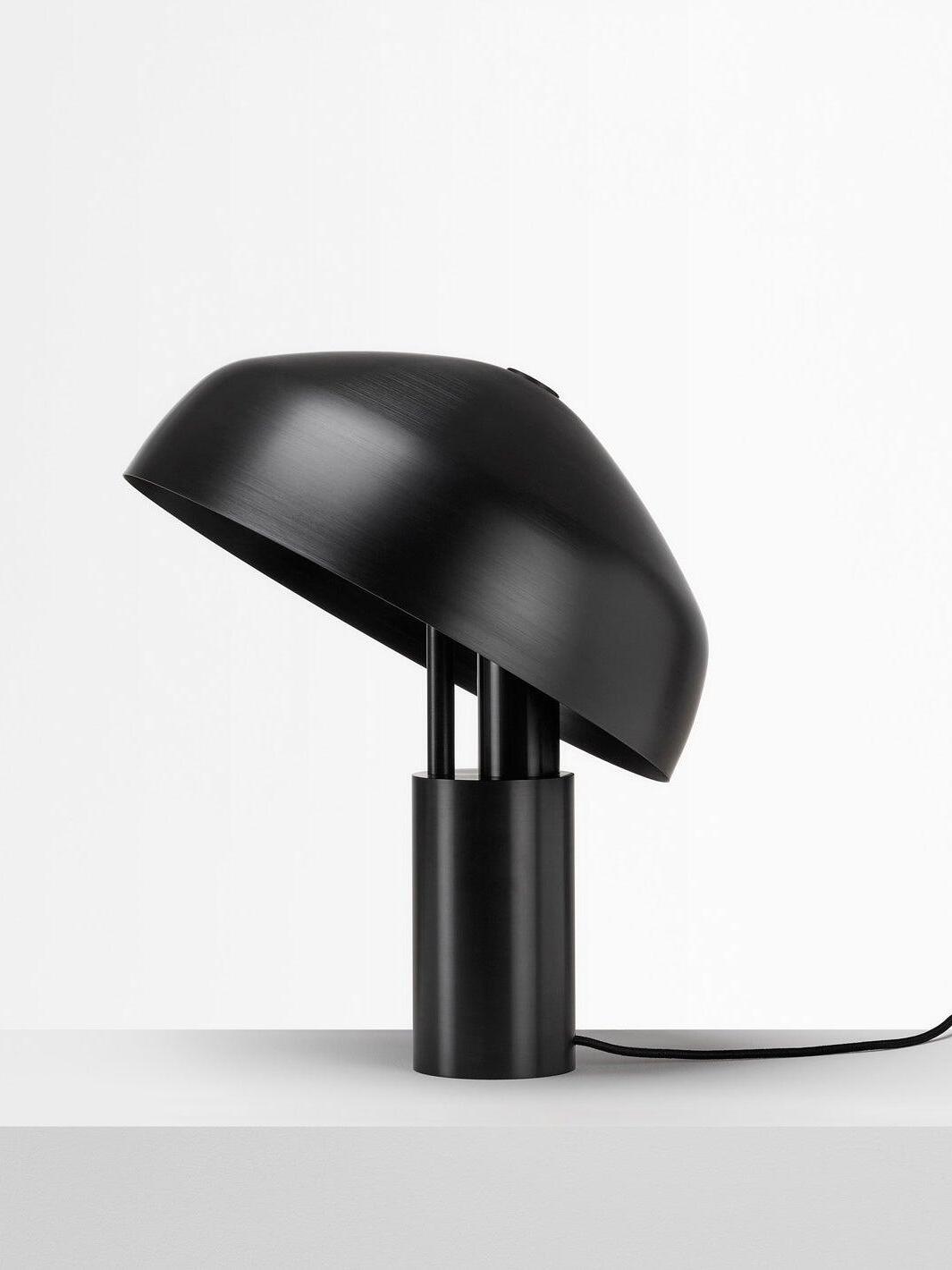 Black metal dome tilted above cylindrical base