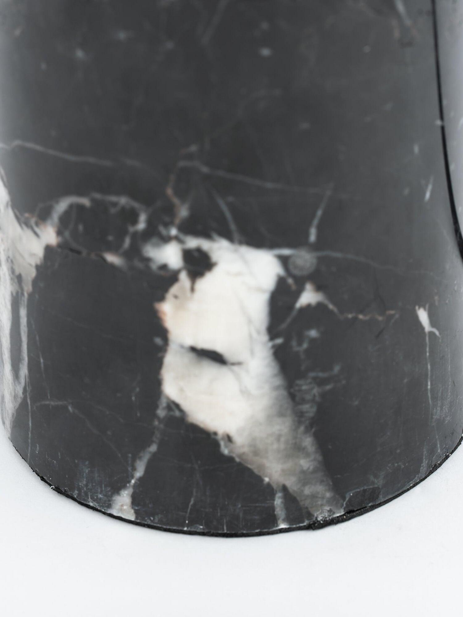 White veining across black cylindrical marble base