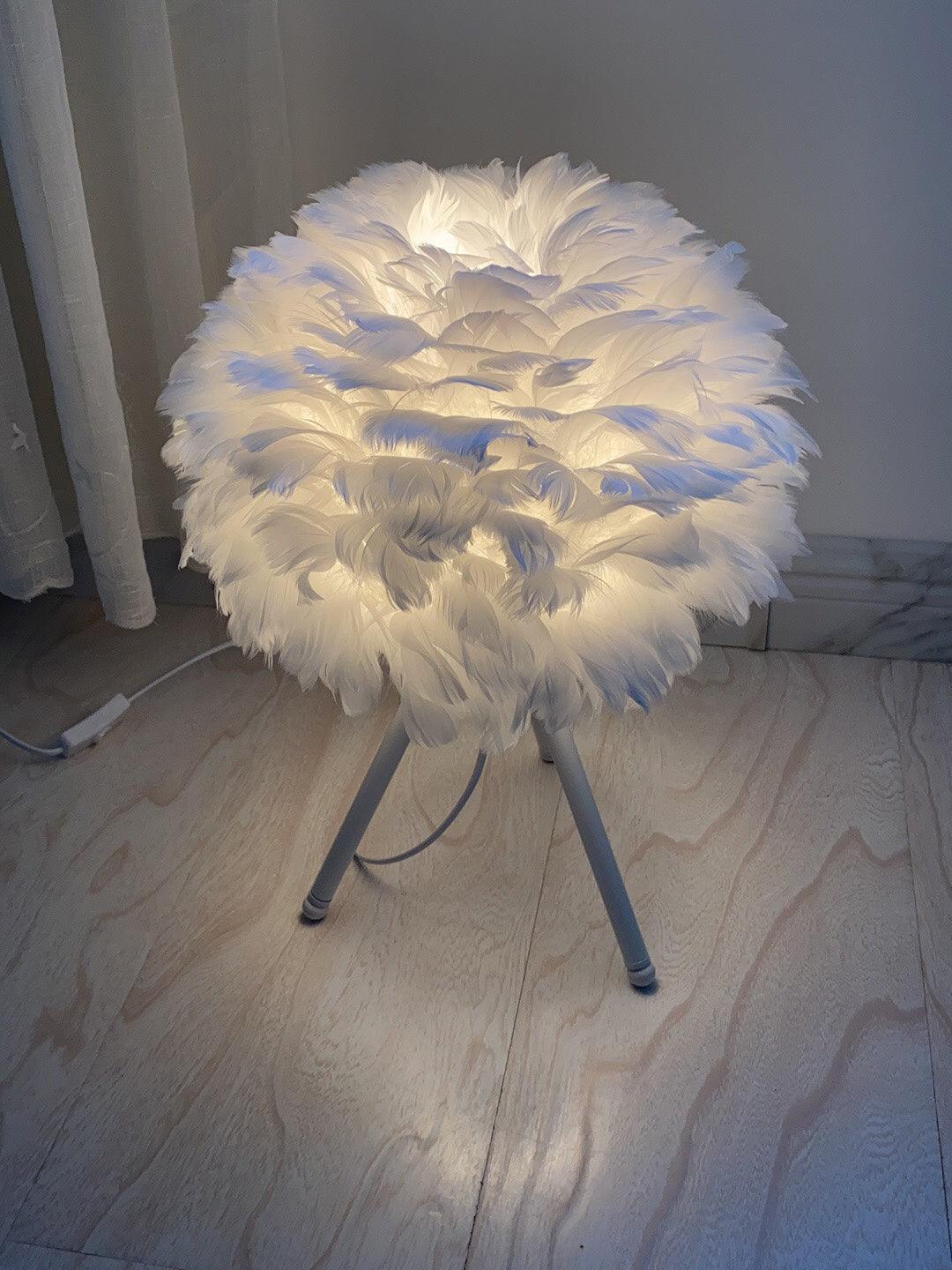 White tripod lamp on pale wooden floor