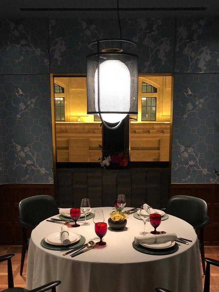 Lit black lantern pendant above round dining table