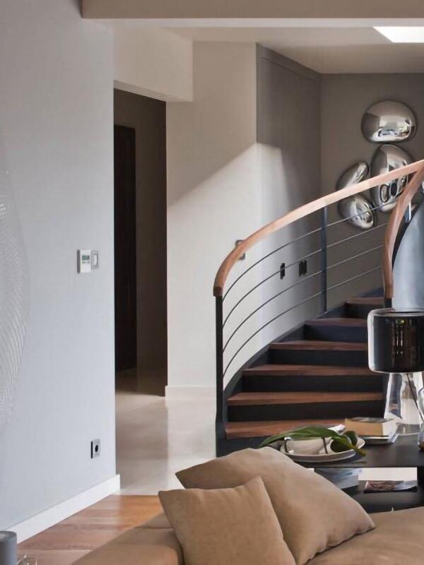 Staircase with curved railing, wall light and separate reflective hanging form