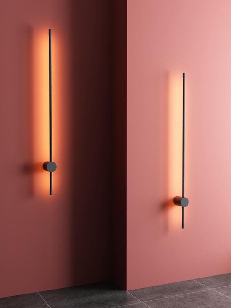 Two vertical linear fixtures against red and pink walls