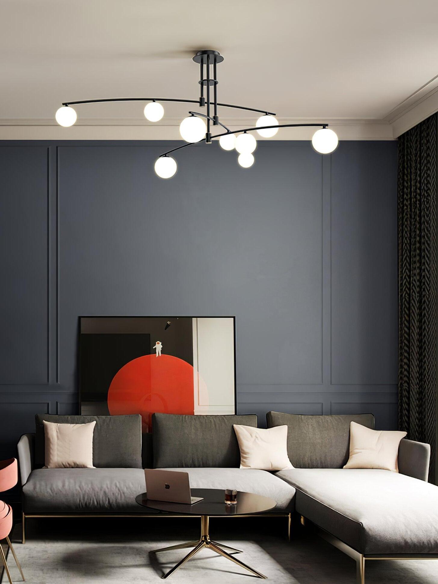 Black globe chandelier above a corner sofa and oval coffee table