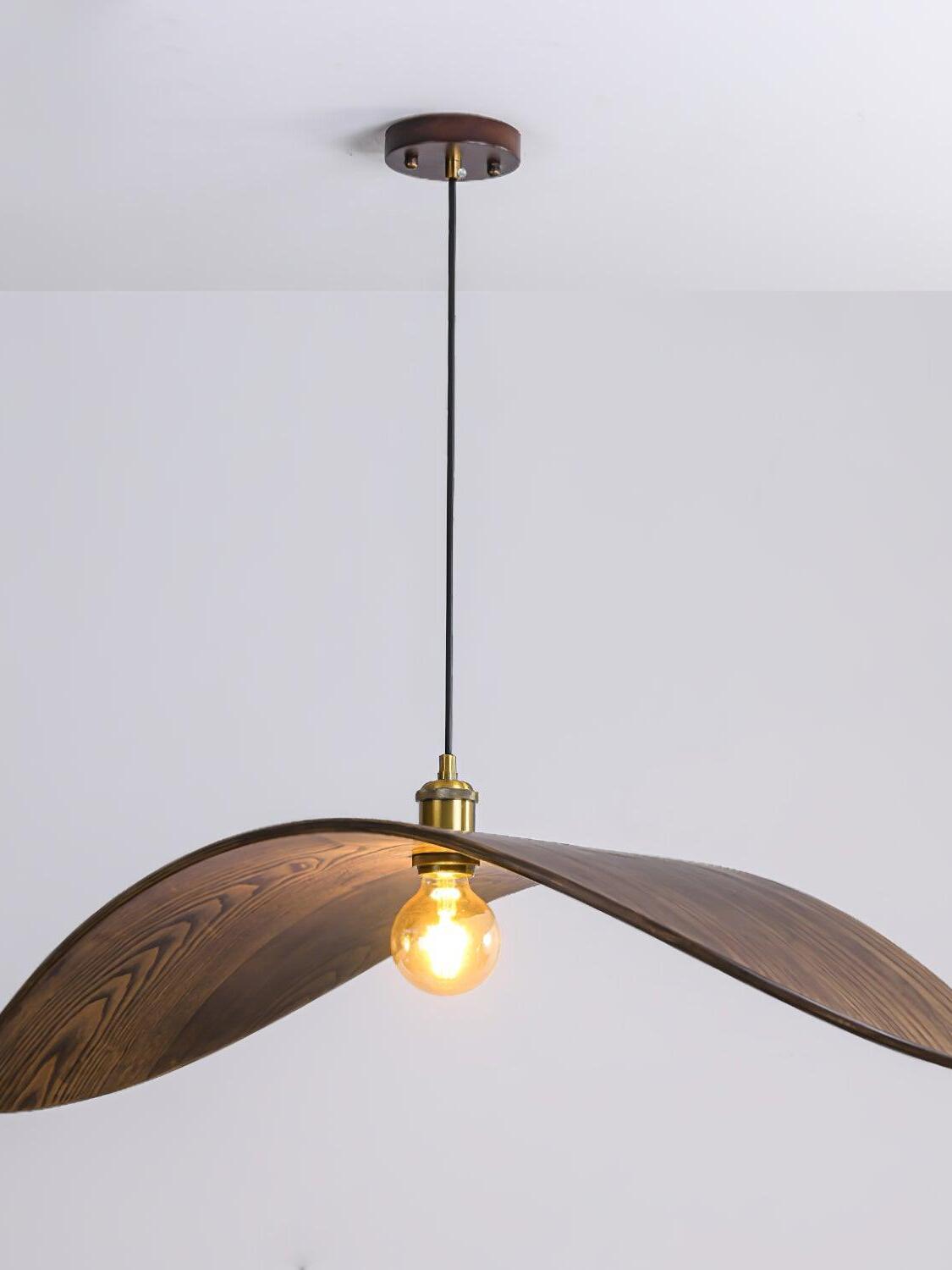 Illuminated central bulb beneath dark curved wood-grain wings with a gold-tone holder and round canopy