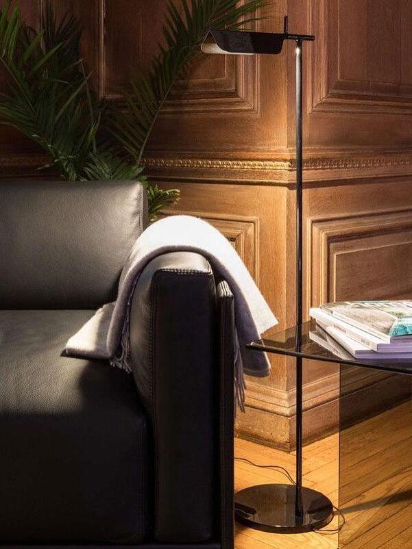 Black floor lamp beside an armchair and side table
