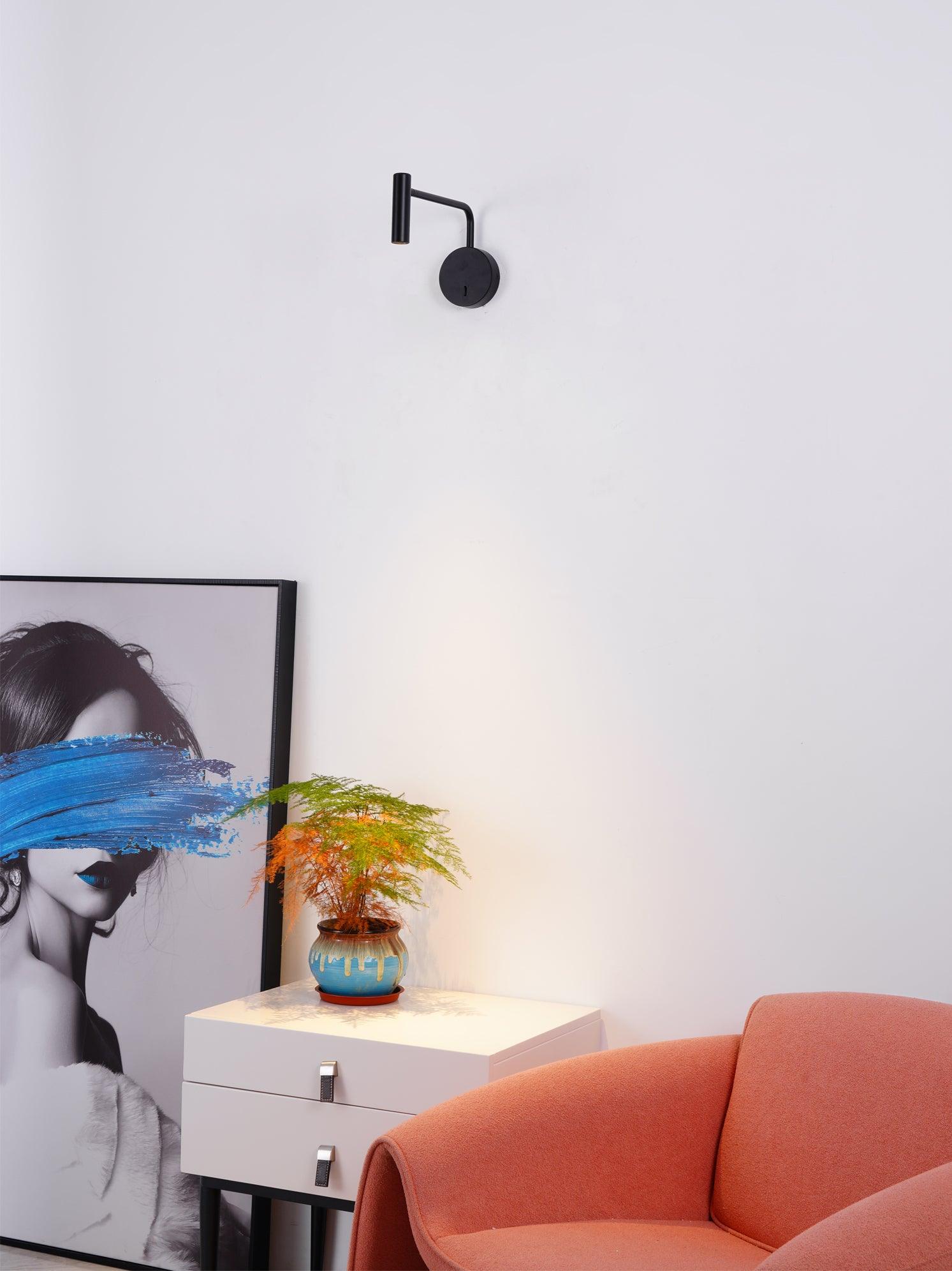 Black wall sconce above a small cabinet