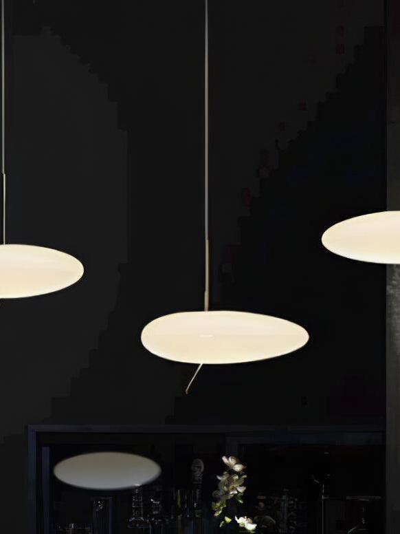 Glowing white pebble-shaped pendant shades suspended against a dark interior