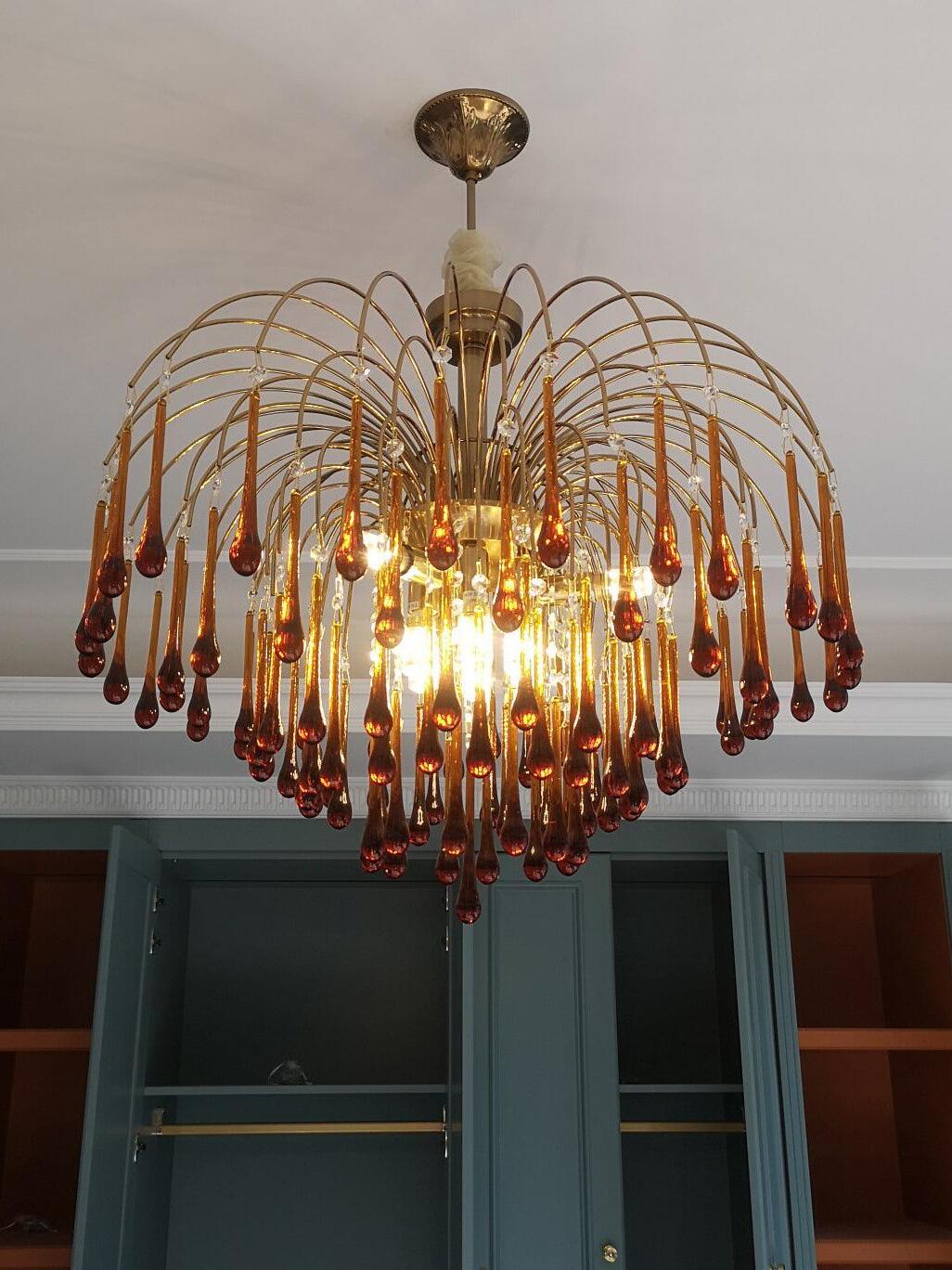 Amber chandelier lit beneath a ceiling canopy
