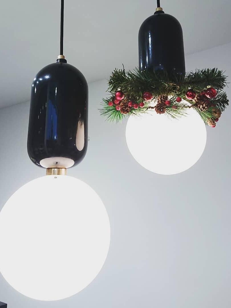 Black-cap globe pendants beside seasonal greenery