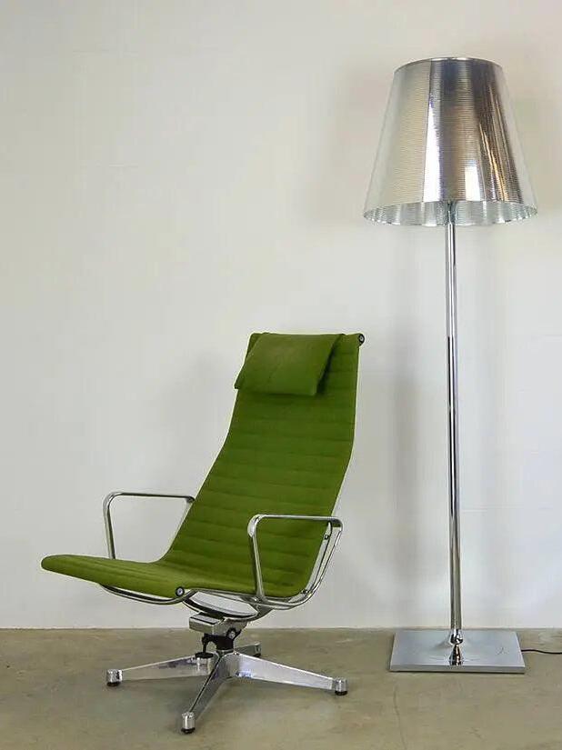 Reflective silver-looking Ktribe lamp beside a green chair