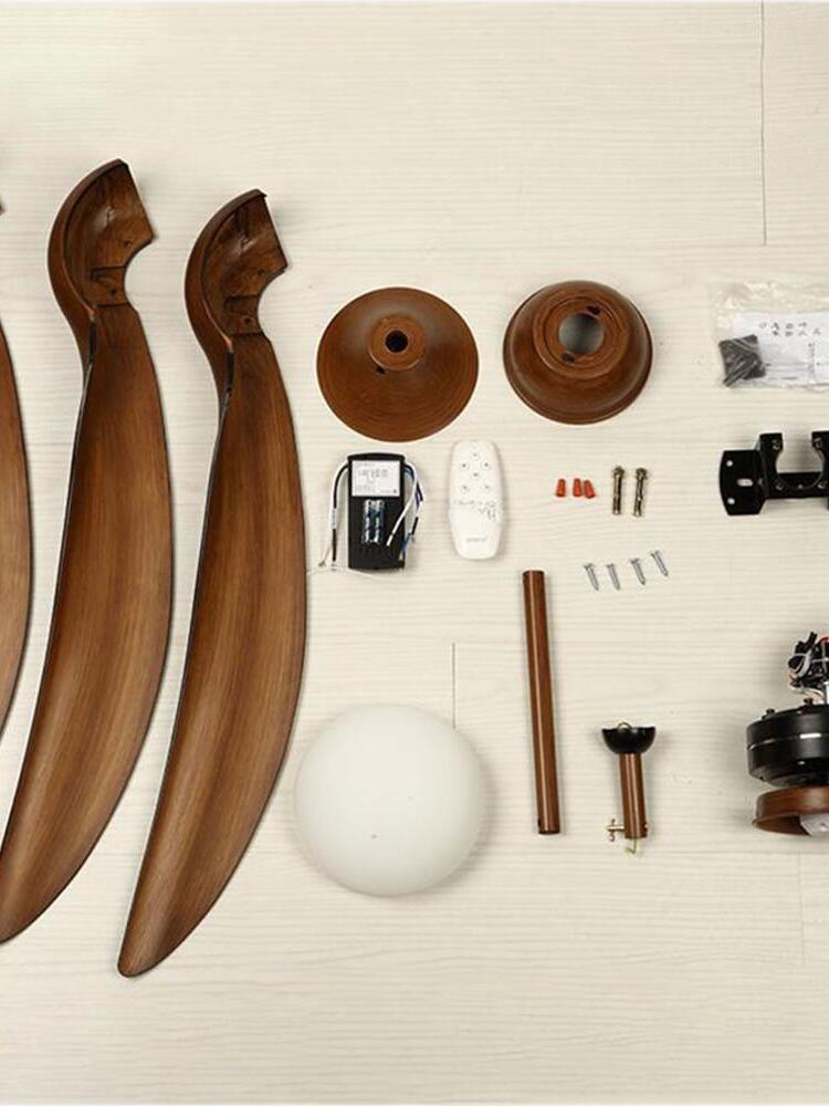 Disassembled brown fan blades, diffuser, remote, wired box, rods, canopy covers and mounting hardware laid out