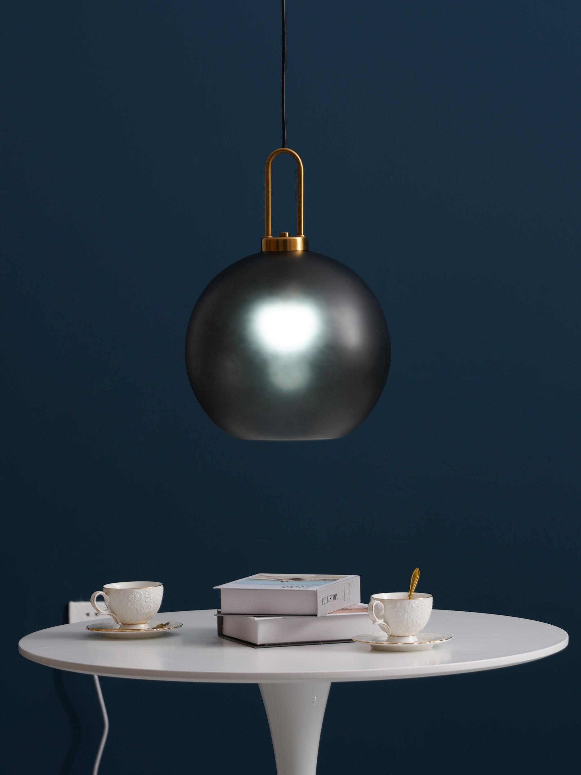 Reflective dark globe pendant over a pale round table