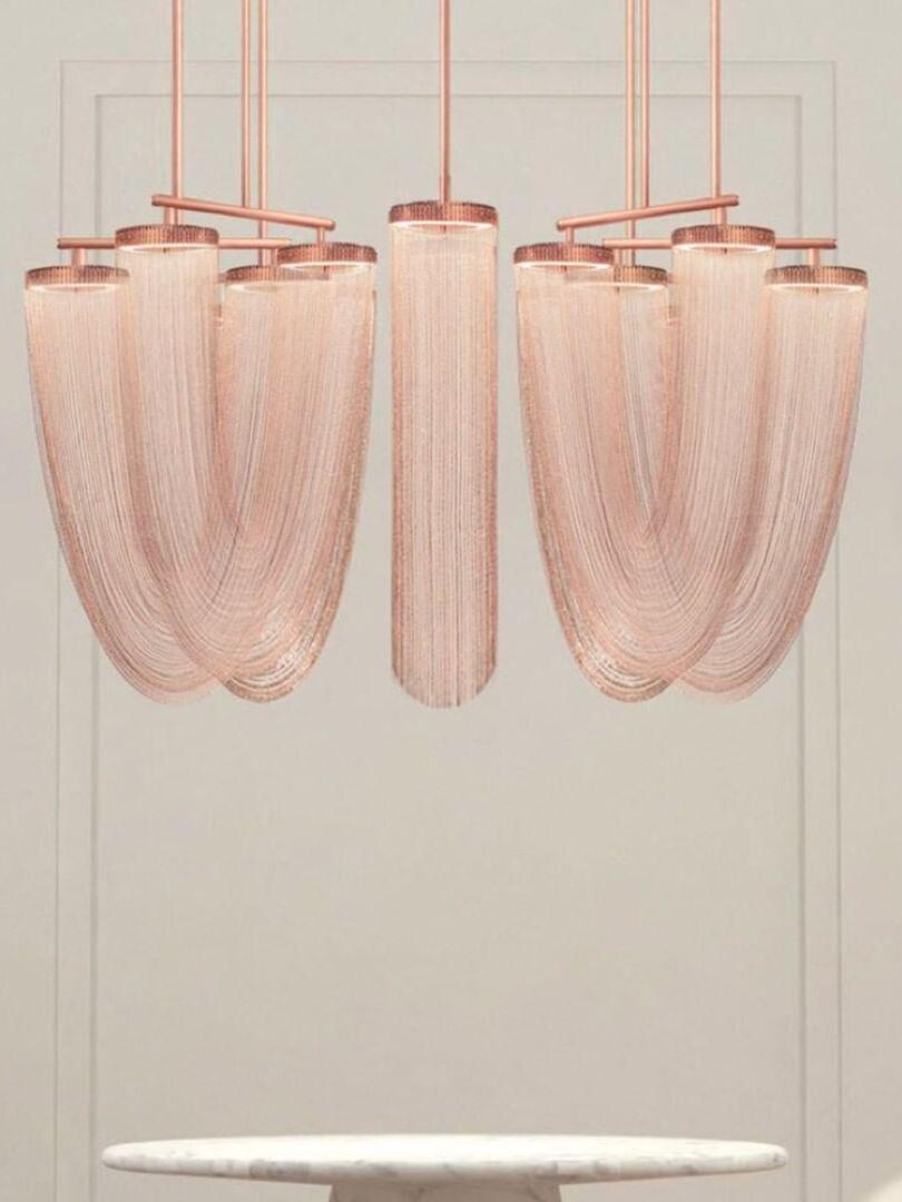 Multiple rose-gold chain loops arranged in a room scene