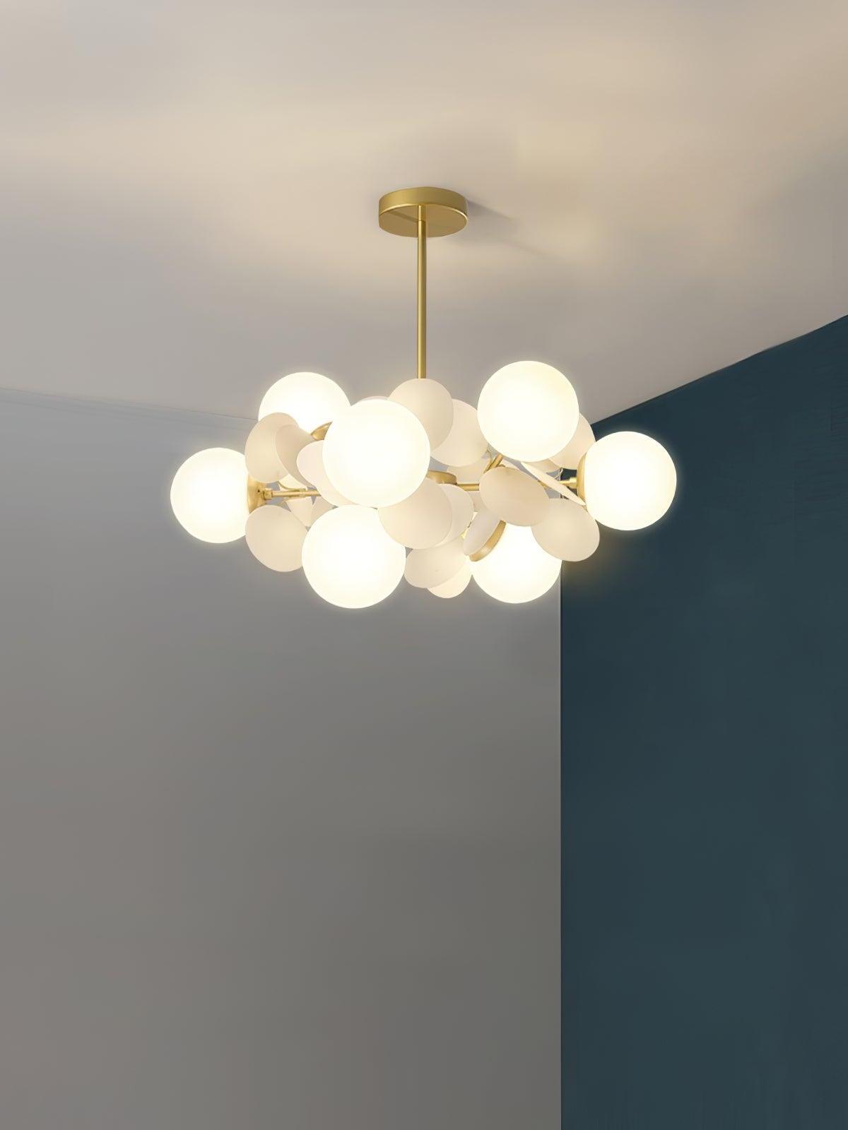 Gold chandelier with eight white globes among white leaf-like discs