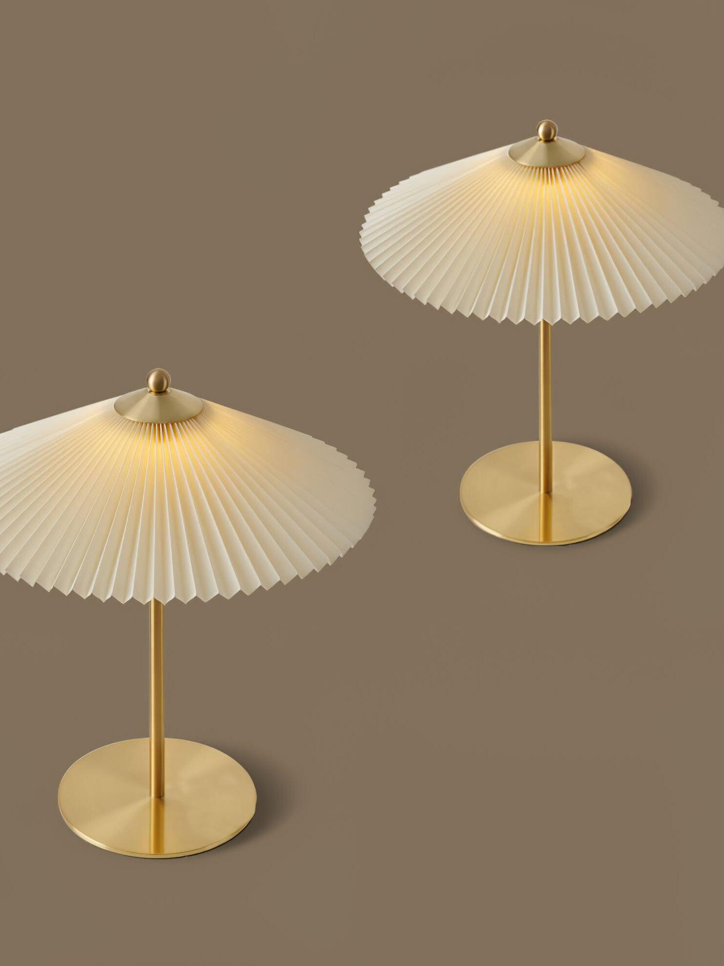 Two Perla-style pleated lamps shown together from different angles against a warm neutral background