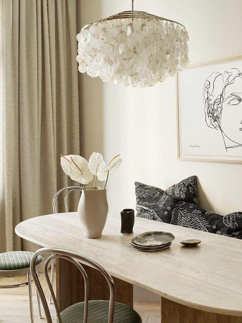 Shell chandelier above a light wooden dining table