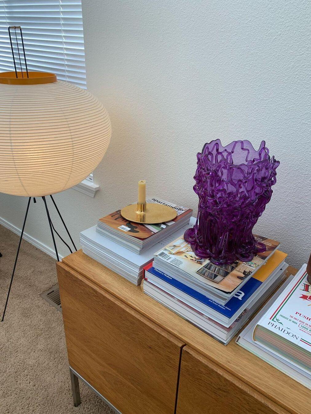 Round paper lamp near a cabinet and books