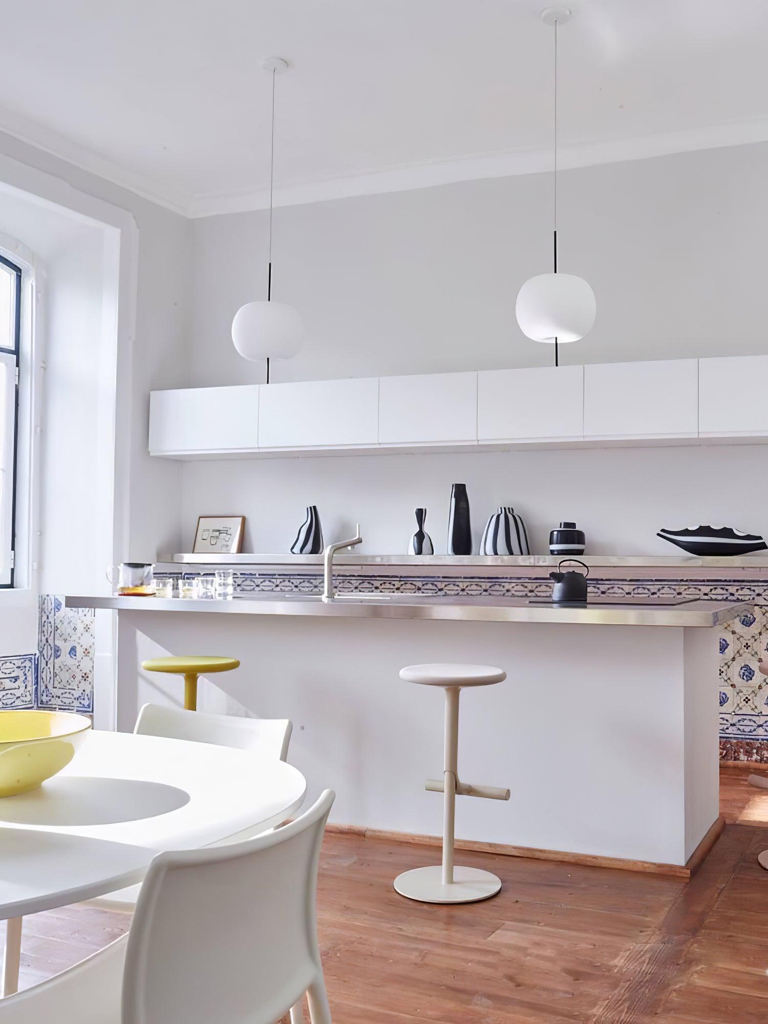 Two white pendant shades above a kitchen counter