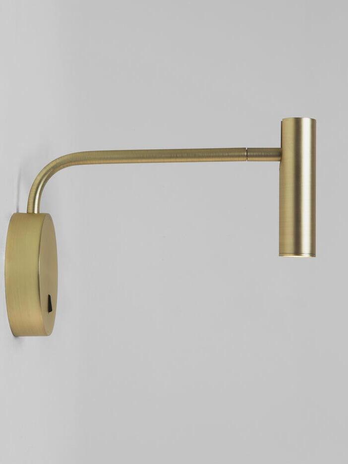 Gold-coloured wall sconce seen from the side