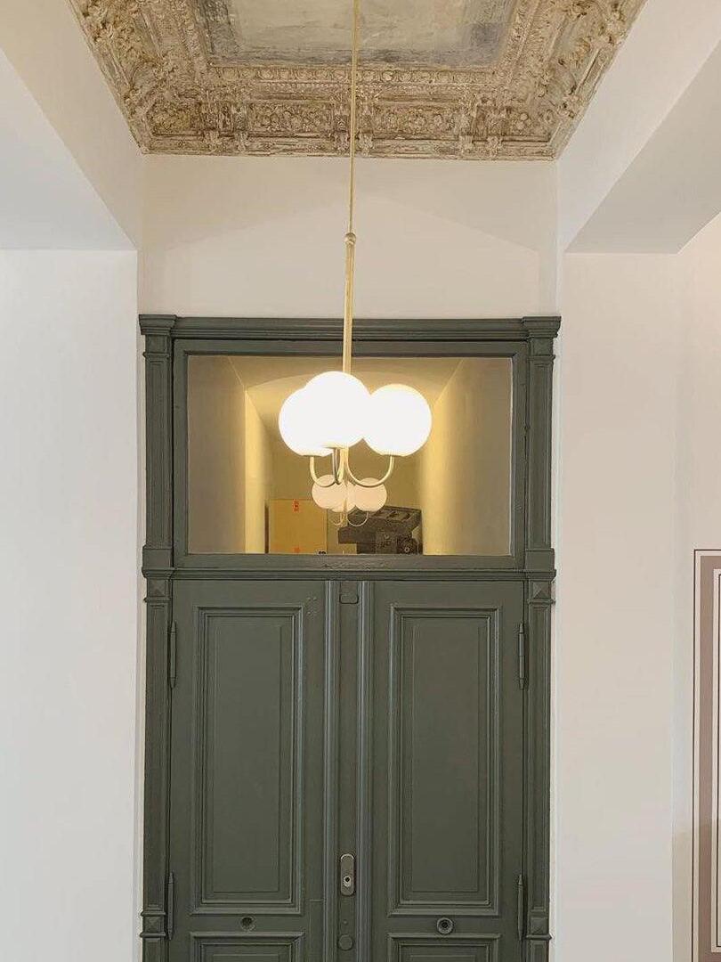 Three-globe Angle pendant in an entryway