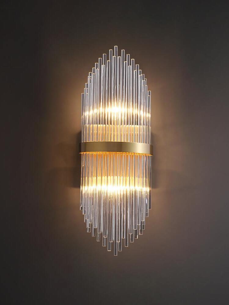 Brass-banded crystal wall light glowing on dark wall