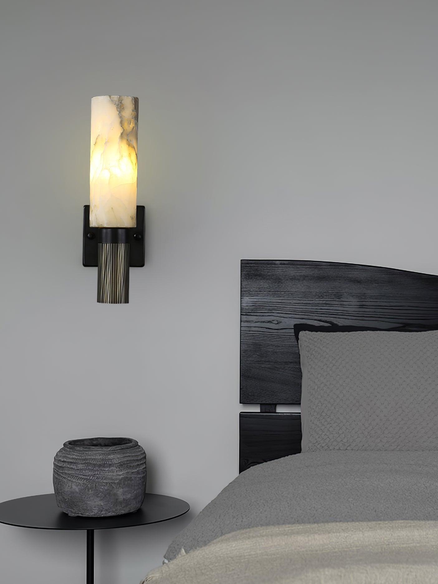 White marble wall sconce above bedside table