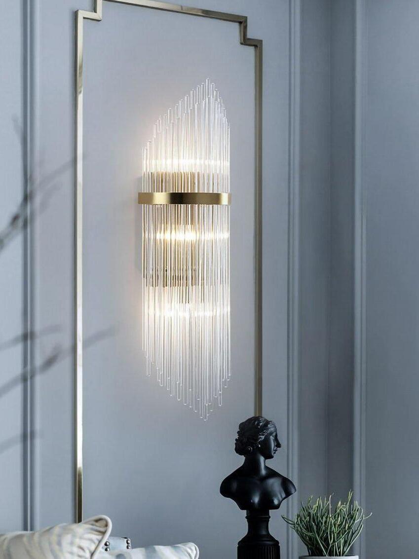 Tall clear crystal rod wall sconce beside framed mirror