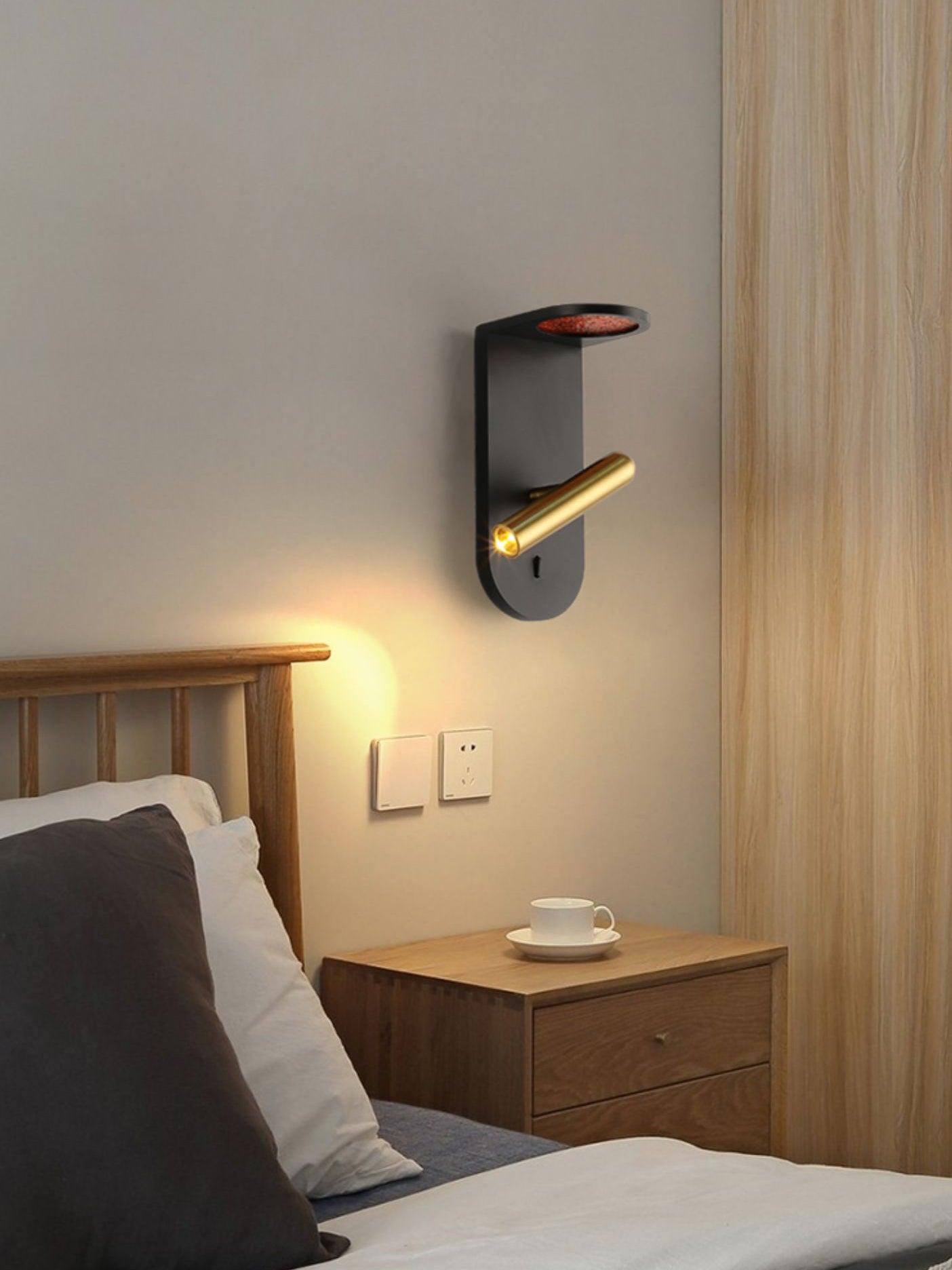 Black Nights wall light with an angled head above a wooden bedside table and headboard