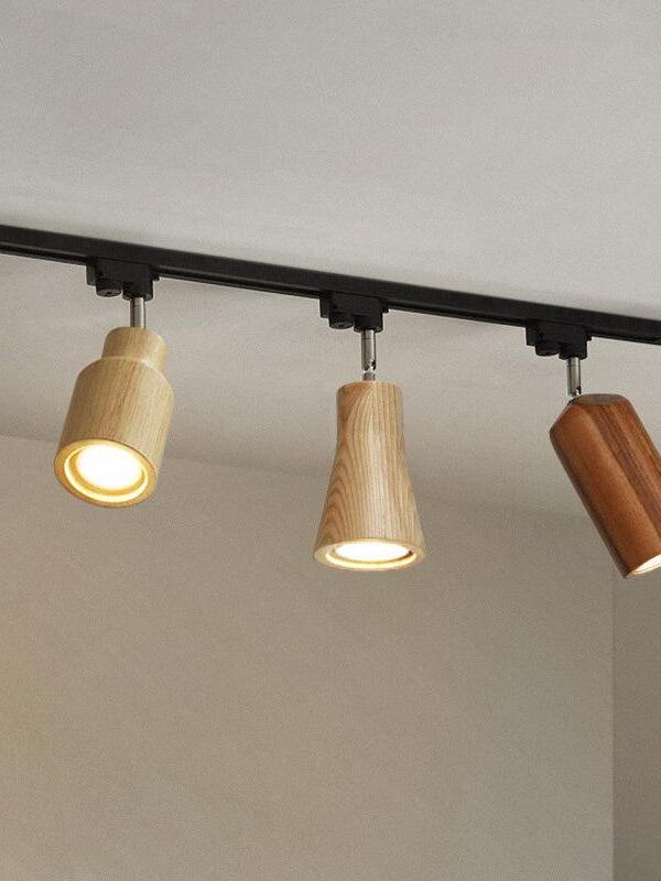 Three differently shaped wooden spots lit on track